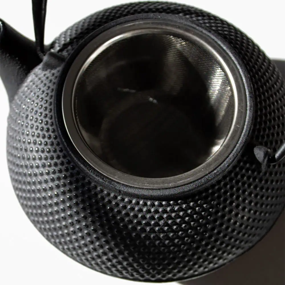 Elegant black cast iron teapot with a 800ml capacity, designed for brewing Carmién Tea. Its textured surface adds a modern touch to traditional tea brewing.