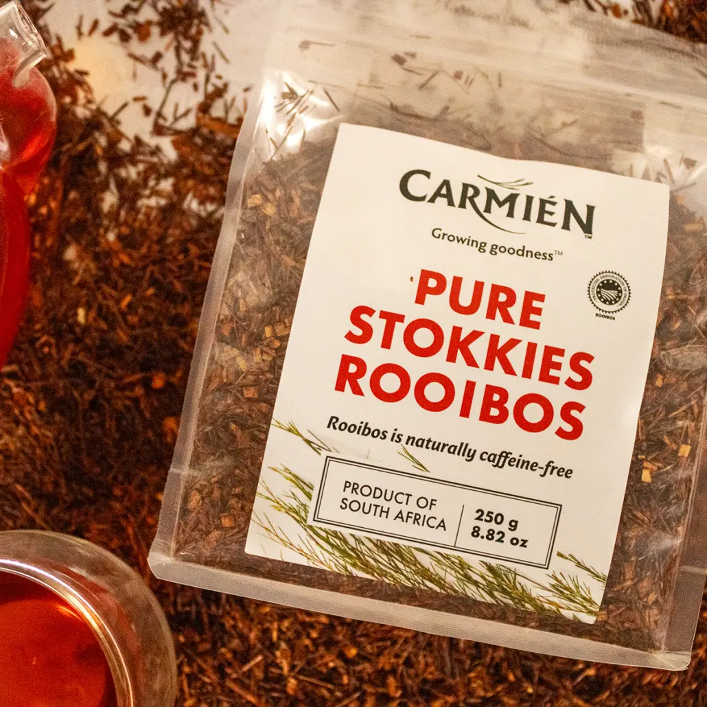 Pure Stokkas Rooibos tea from South Africa, organic and caffeine-free, displayed in a clear plastic bag with traditional packaging highlighting Rooibos benefits and natural growth.