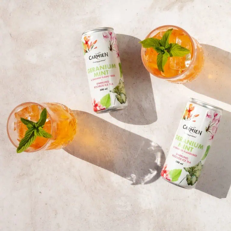Refreshing Carmién Geranium Mint Rooibos Ice Tea cans with mint garnish, perfect for a cooling summer drink, highlighting natural ingredients and vibrant citrus flavours.