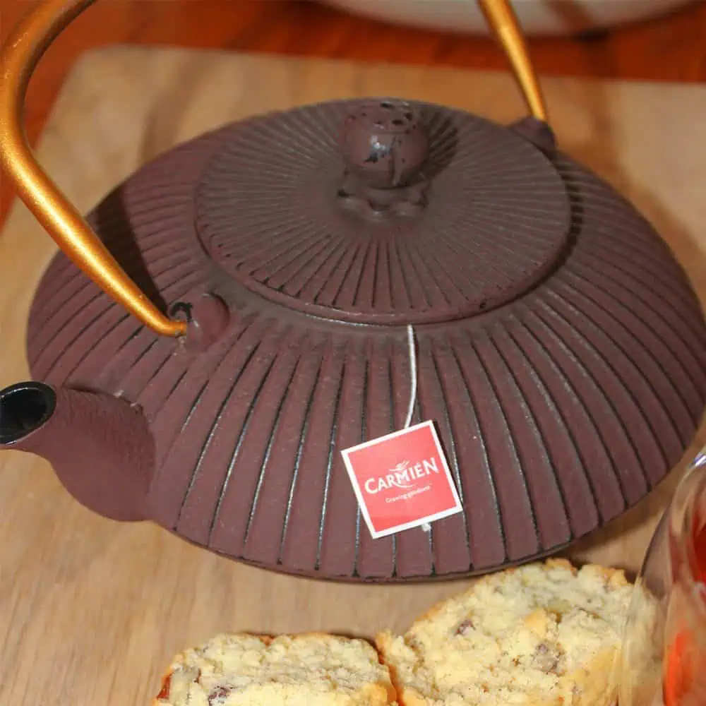 Elegant maroon and gold cast iron teapot for brewing tea. Perfect for traditional tea ceremonies and adding a touch of sophistication to your tea experience.