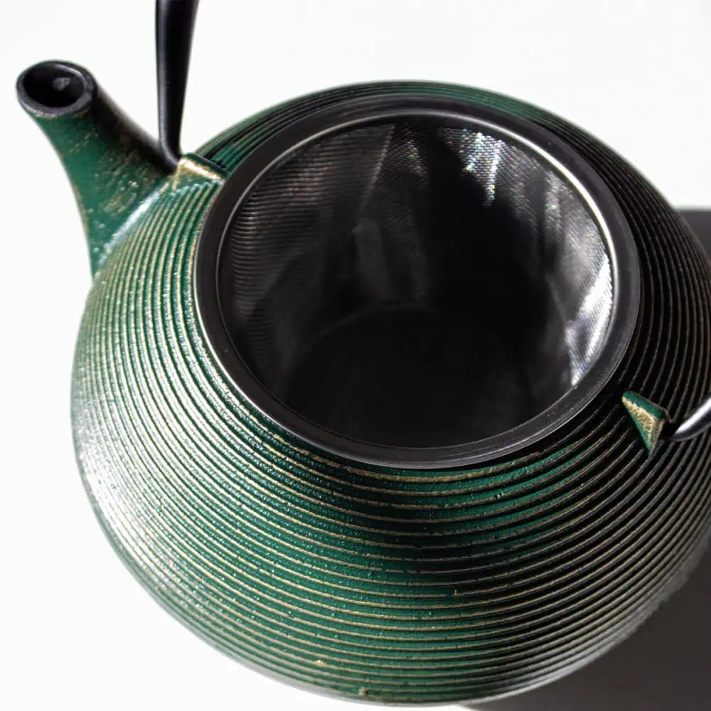 Elegant emerald green cast iron teapot with a textured finish, perfect for brewing and serving tea. Durable and stylish, ideal for tea lovers seeking quality and aesthetic appeal.