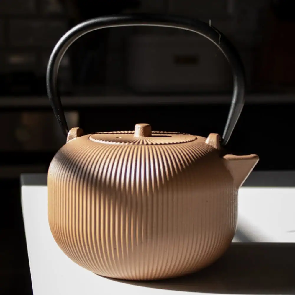 Elegant sandstone cast iron teapot with textured surface, perfect for brewing traditional tea. Crafted for durability and style, ideal for tea lovers seeking quality and aesthetic appeal.