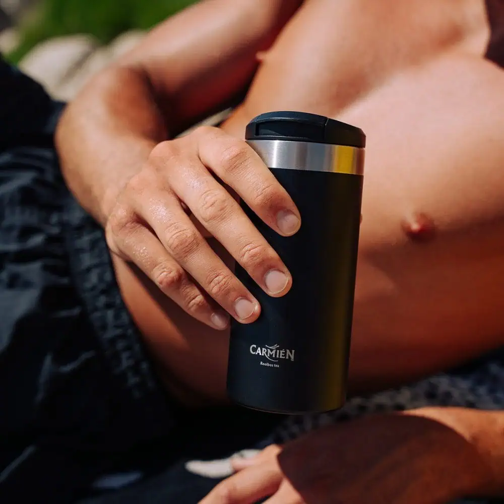 Travel mug with Carmién Tea branding, black finish, and stainless steel lid, ideal for hot beverages on the go.