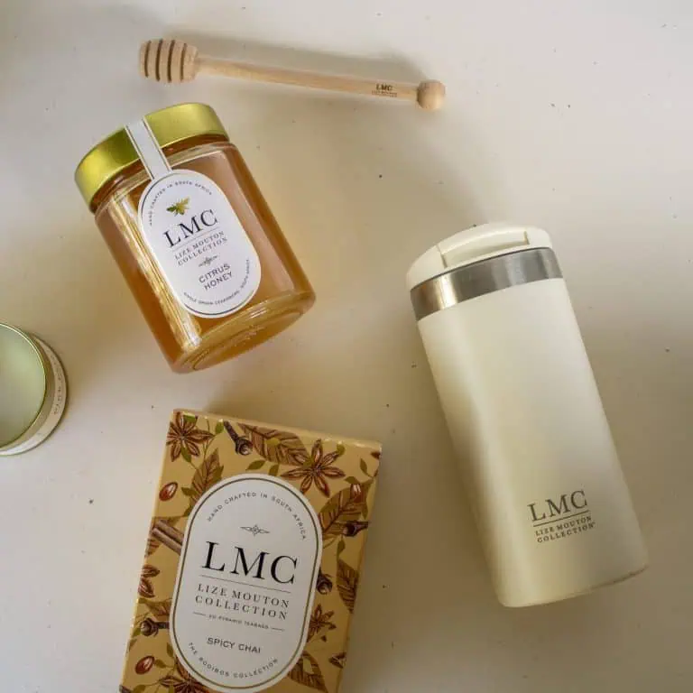 Aromatic CarmiƩn Tea products including honey, tea, and a thermos on a white surface, highlighting natural South African herbal tea gifts and collection.