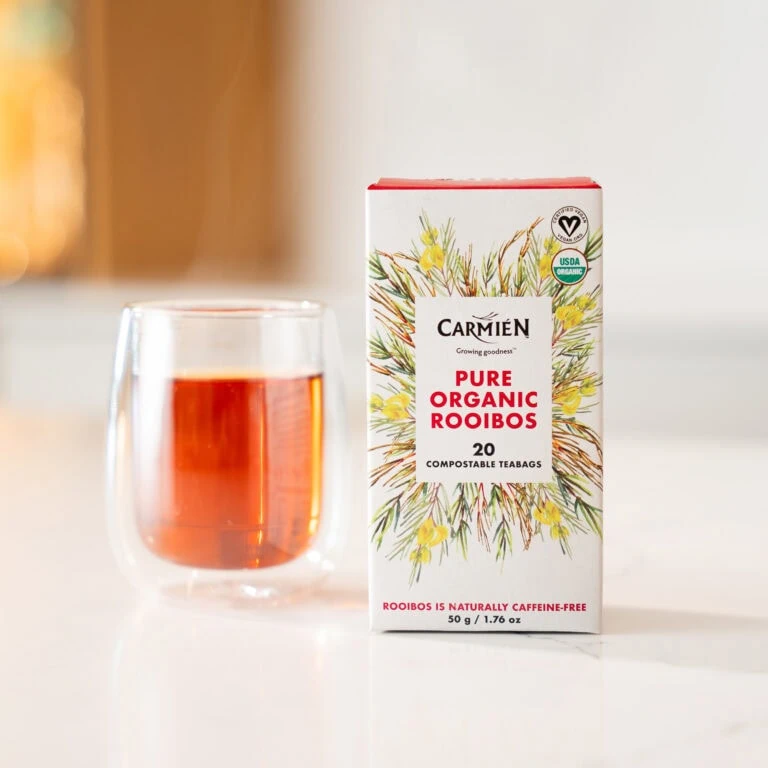 Organic Rooibos tea in a box with a glass of brewed tea beside it, highlighting natural and organic qualities.
